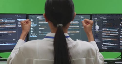Happy Woman Developer Celebrating And Dancing While Write Code With Multiple Screens In Green Screen