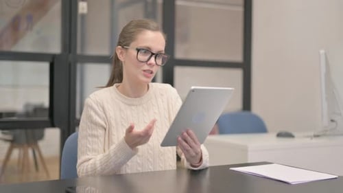 Young Woman Doing Video Chat on Tablet in Office