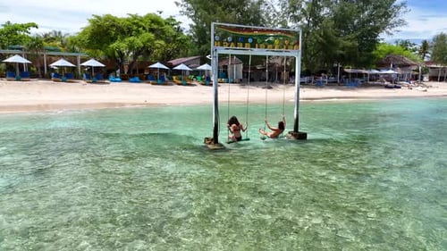 Women on Swings at Tropical Beach Paradise