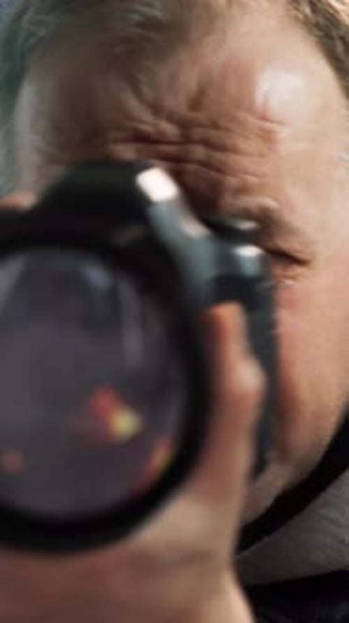 Man Filming Riot Through Camera Lens in Vertical Format