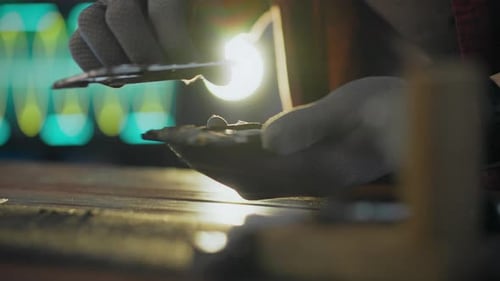 Hands Repairing a Phone with Gray Gloves