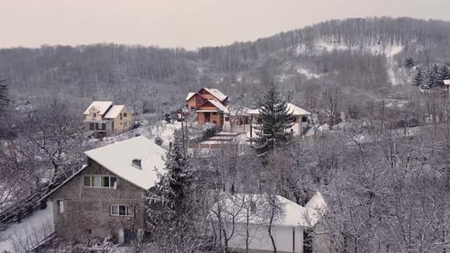Drohnenblick über ein kleines verschneites Dorf im Winter, Luftbild