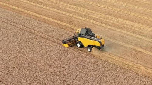Aerial view of combine harvester working on farmland