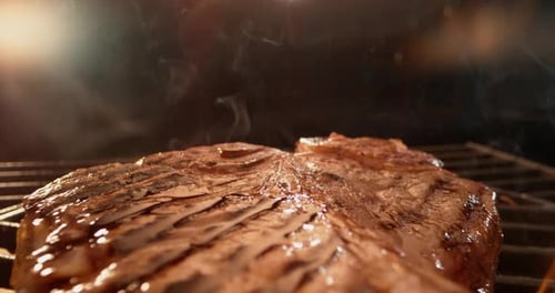 Steak en forme de T grésillant sur le gril