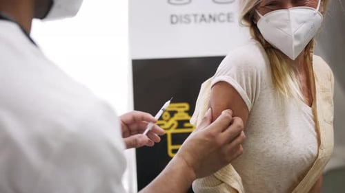 Adult Woman Receives Injection from Doctor in Clinic
