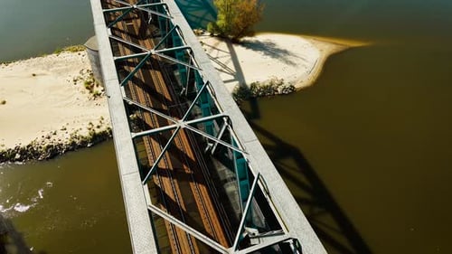 Puente ferroviario que pasa sobre el río Muddy con banco de arena visible y riel de hierro con estructura de celosía metálica