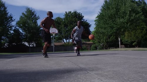 Street basketball player blocked in energetic one on one city matchup