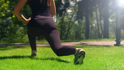 Sporty Woman Doing Stretching Exercises Outdoor. Fitness Girl Doing Lunges in Park
