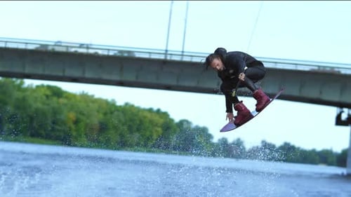 Atleta de wakeboard saltando por encima del agua. Acrobacia extrema sobre el agua. Truco profesional