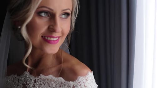 Beautiful Bride Smiling near a Window on Wedding Day