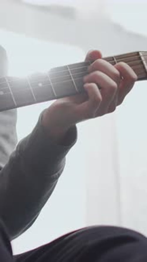 Person Playing Acoustic Guitar Indoors