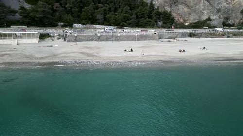 Drone Moving Away From the Coast Out to Sea on a Day with Calm Seas Near the Sand