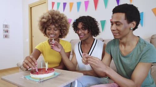 Friends Putting Candles on Birthday Cake at Home