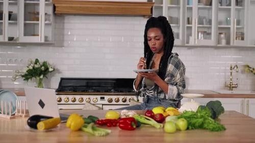 Young Woman Eating Healthy in Bright Kitchen