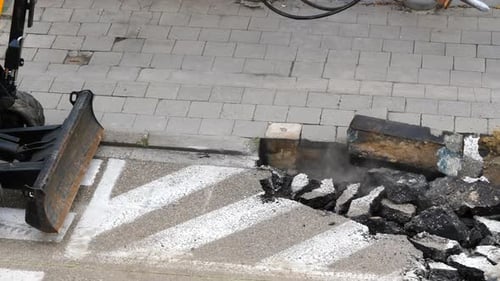 High angle static shot of hydraulic breaker breaking asphalt. Close up