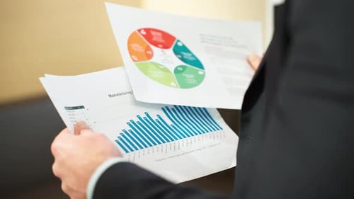 A professional examines an infographic and bar chart for data analysis and insights