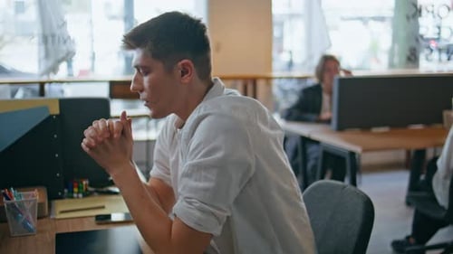 Stressed Young Adult Thinking at Modern Office Desk