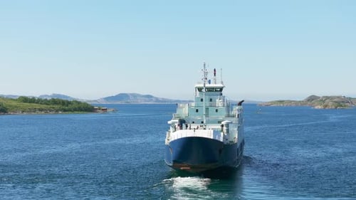 Drone orbit arctic Norway ferry revealing pointed waterfront mountain by fjord