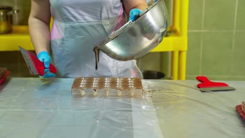 Craftsperson Pours Melted Chocolate Into Mold