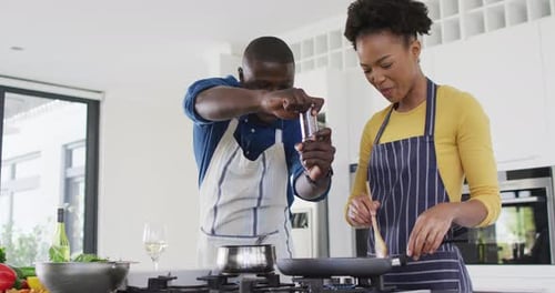 Video of happy african american couple cooking together