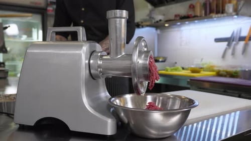 The Chef Makes Minced Meat in a Meat Grinder in the Kitchen of the Restaurant