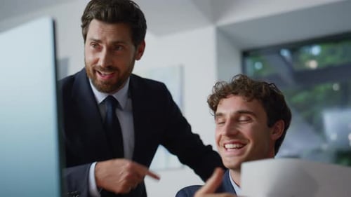 Two Businessmen Collaborating on Computer in Modern Office