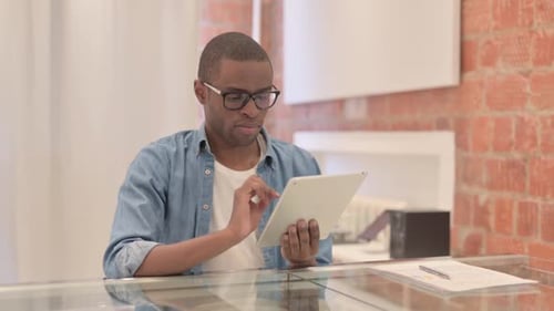 Man Working on Tablet at Bright Desk