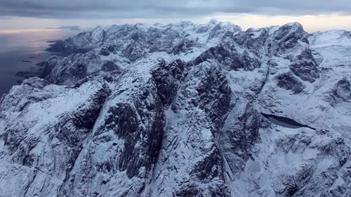 Eine Weitwinkelaufnahme zeigt die majestätischen schneebedeckten Gipfel der Rocky Mountains unter turbulenten Winden und
