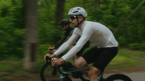 Cyclist in White Hardhat Overtakes Competitor on Bicycle Racing