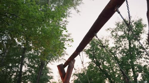 Himmelsansicht auf Holzschaukel und Ketten im Park