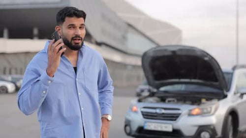 Man on Phone Near Car with Hood Open