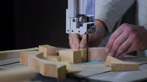A man works with wood in a workshop. Working with wooden blanks. A man drills holes in wooden blanks
