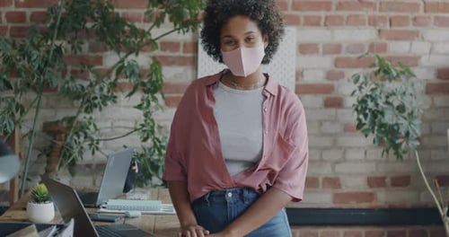 Portrait of African American Lady Employee Standing in Office Wearing Medical Face Mask Looking at