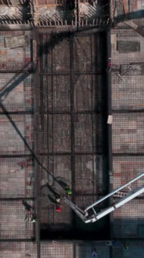 Vídeo vertical Escena de construcción activa captura a trabajadores colocando ladrillos y construyendo paredes con