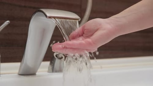 Water Flowing from a Modern Silver Faucet
