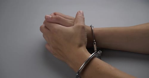 Hands in Handcuffs Clasped in Front
