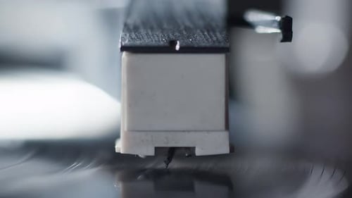 Breathtaking close-up of the needle of a record player being manually placed on the record while a