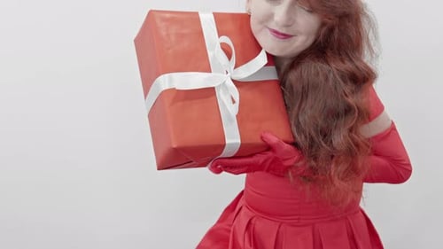 Woman Gently Holds Birthday Gift in Red Dress