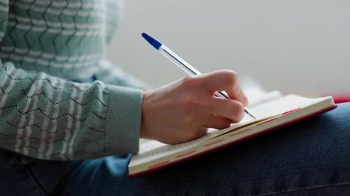 Hand Writing in Notebook with Blue Pen