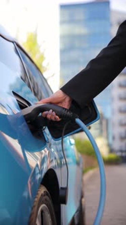 Electric Car Charging with Power Cable in Urban Setting