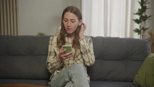 Serious Woman Using Smartphone in Apartment Student Sitting on Her Phone