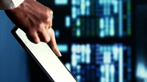 Hand Interacting with Tablet Device Showing Charts