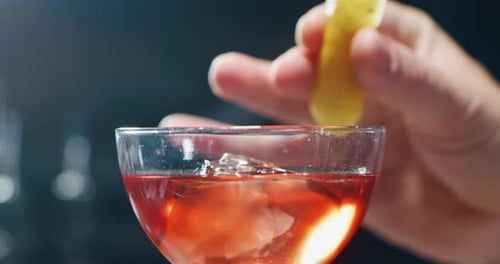 Das Makro eines professionellen Barkeepers ist das Auspressen einer Zitrone bei der Zubereitung eines alkoholischen Cocktails mit