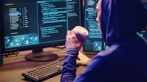 Hacker at Computer Running Spyware