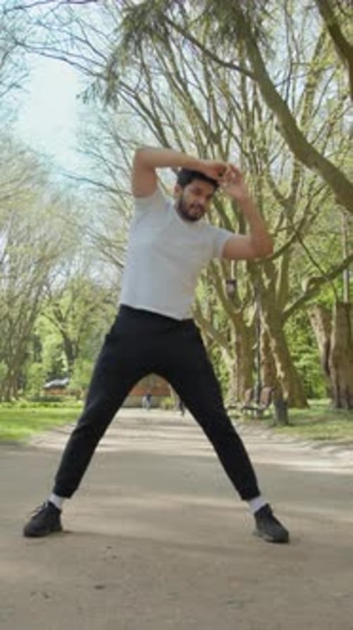 Man Stretching in Urban Park on Sunny Day
