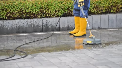 Cleaning a Stone Pathway With a Pressure Washer in a Garden Area