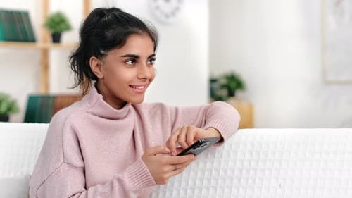 Woman Relaxing at Home with Smartphone