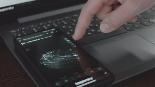Finger Using Phone Displaying Cyber Threat Map