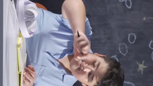 Boy Studies at Desk with Headphones and Notebook
