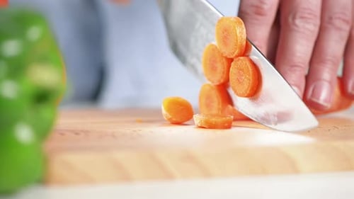 Hands Dicing Fresh Carrot With Sharp Knife